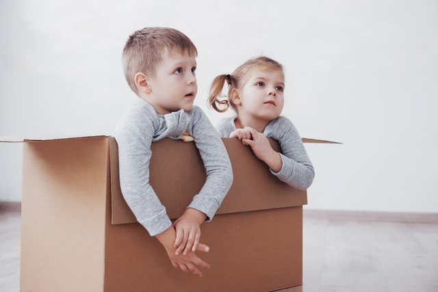 two kids in a cardboard moving box