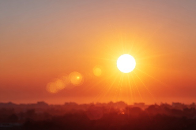Summer heatwave with bright sun over a red horizon.