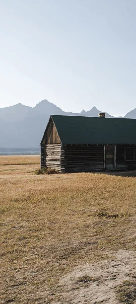 Rustic log cabin with mountains in background