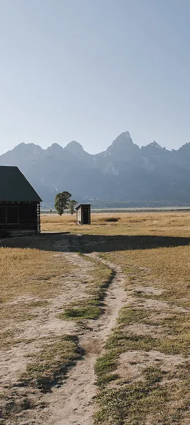 Small path leading to an outhouse near mountains