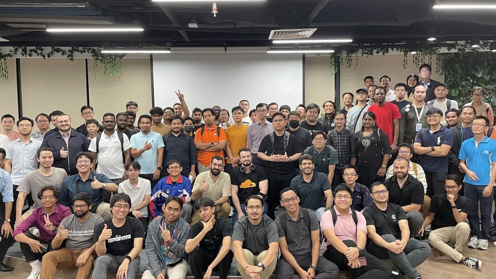 A diverse group of attendees at the Cloud Native Kuala Lumpur Meetup, posing for a group photo.