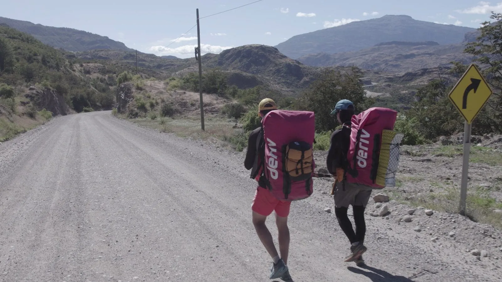 متنزهون يحملون حقائب ظهر تحمل علامة Deriv التجارية.