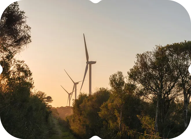 A couple of windmills that are standing in the grass.