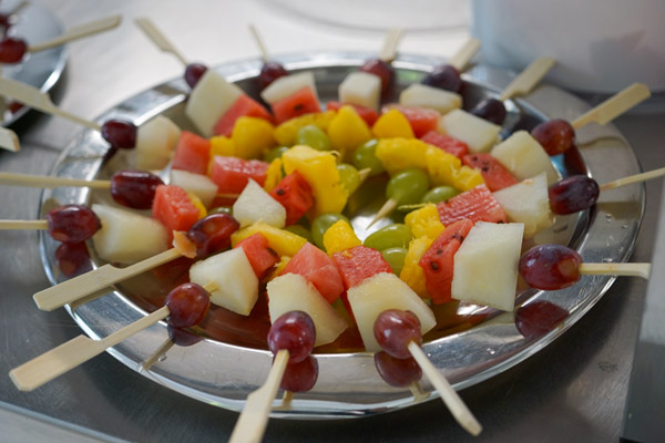 Een kleurrijke schotel met fruitspiesjes ligt klaar om geserveerd te worden aan de bezoekers van het feest.