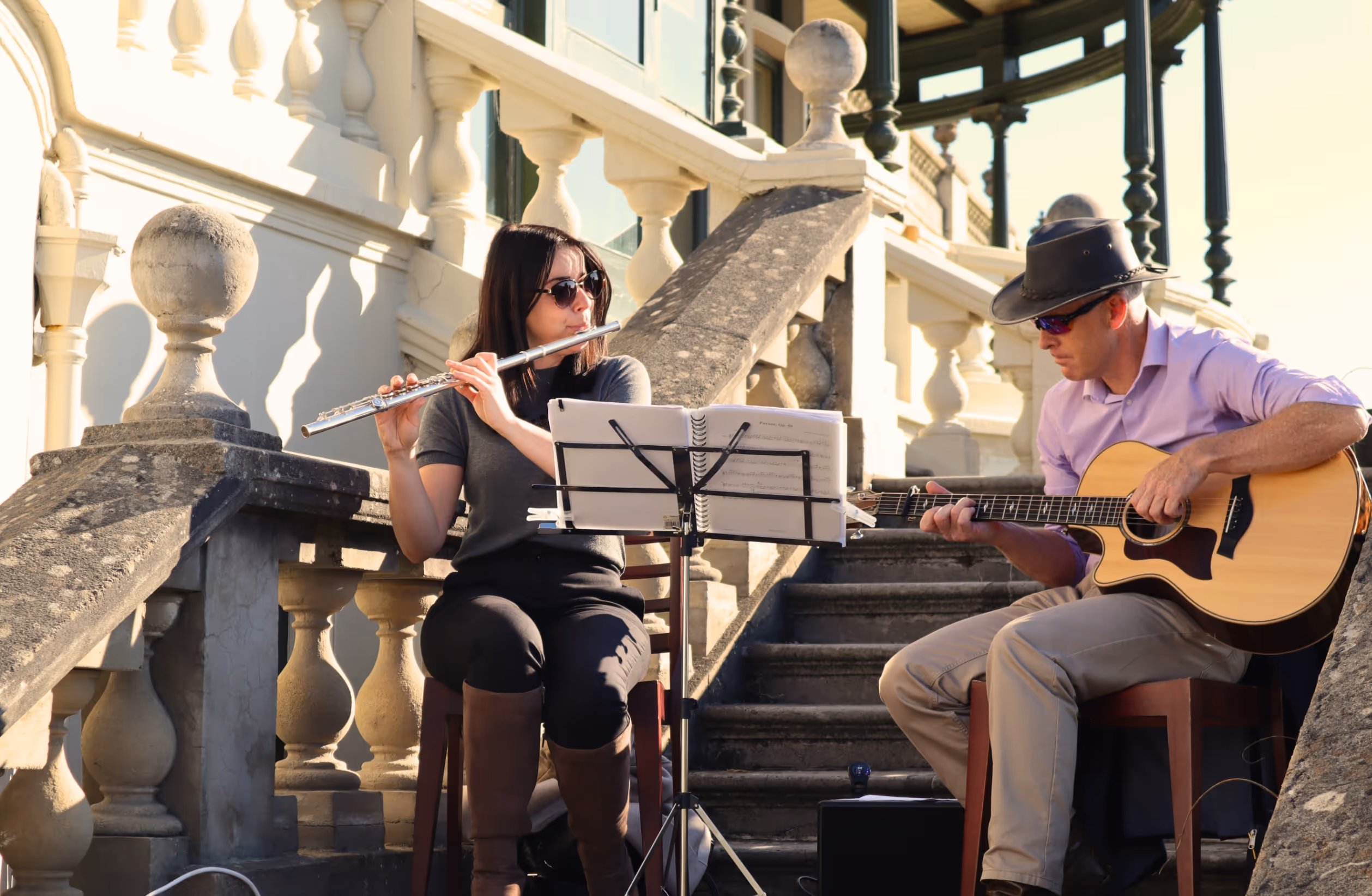 Musicians playing flute and guitar in the sunlight on the Terrace steps of the Russell-Cotes Museum