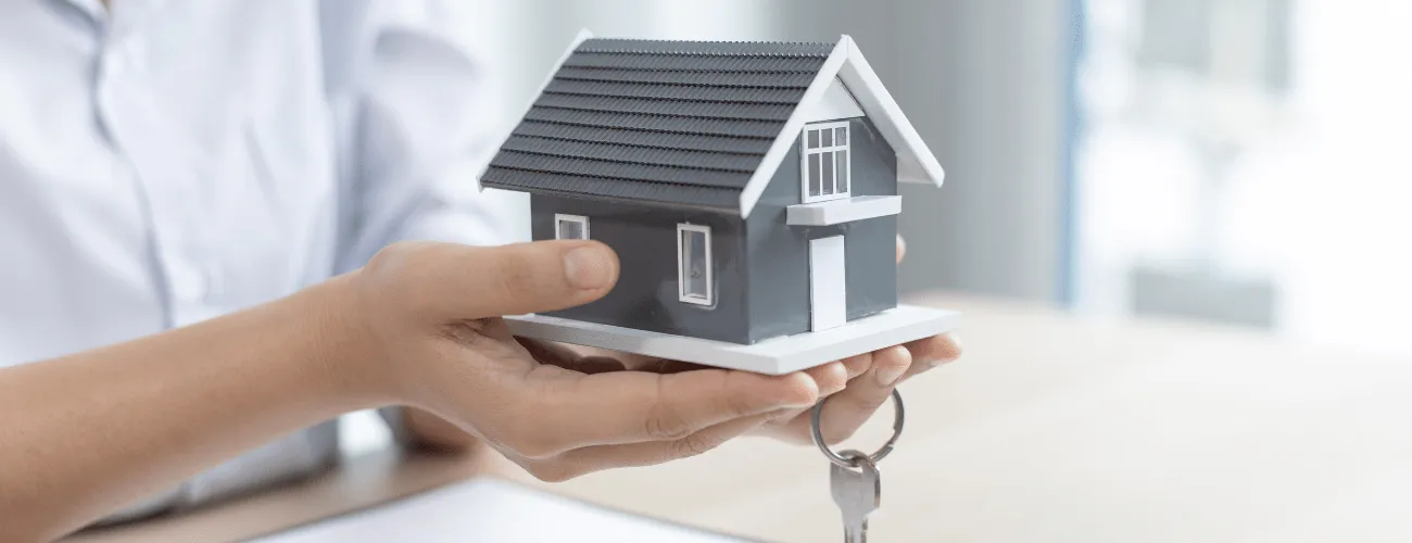 A Woman Holds a House and Keys in the House