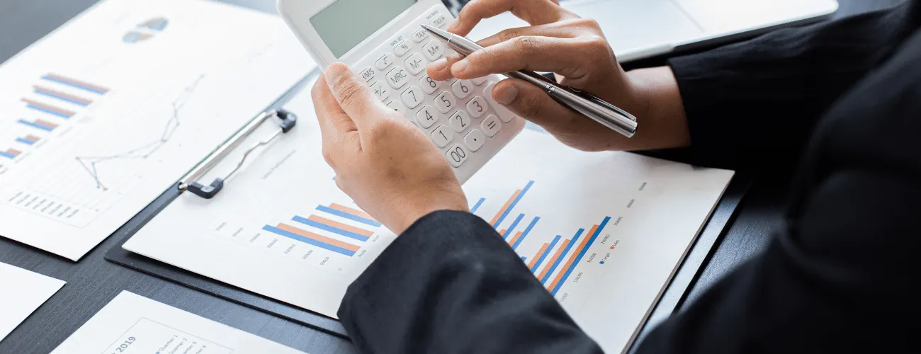 une personne a un bureau qui utilise sa calculette pour calculer les impôts