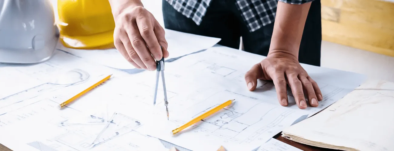 une table avec un architecte qui travaille sur des plans pour rénover une résidence