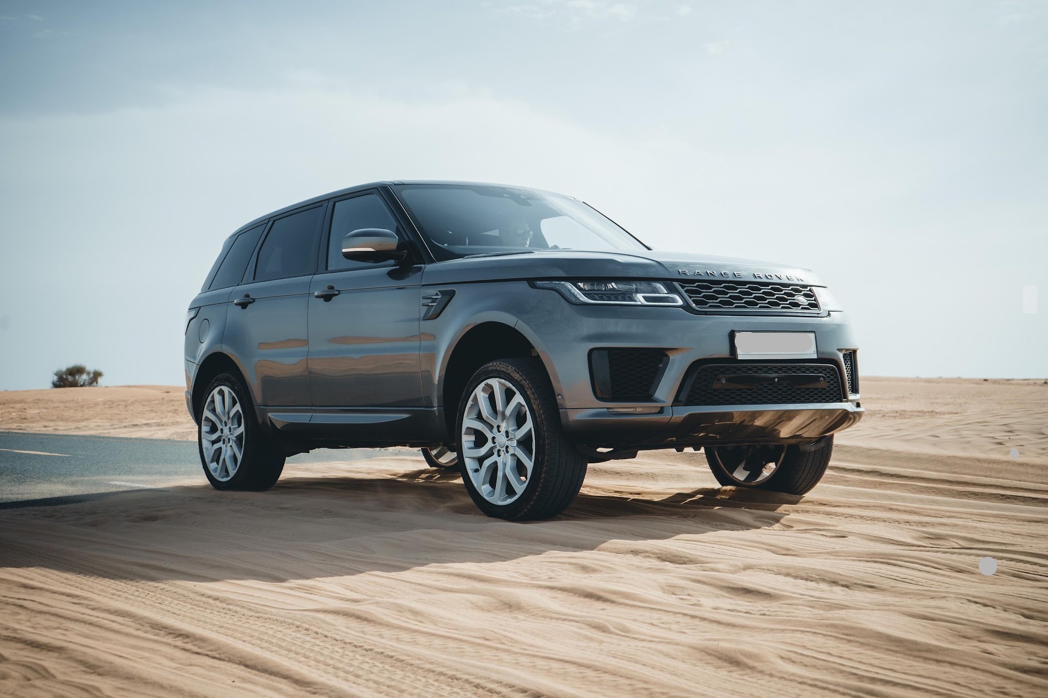 Sleek SUV parked on sandy Dubai terrain
