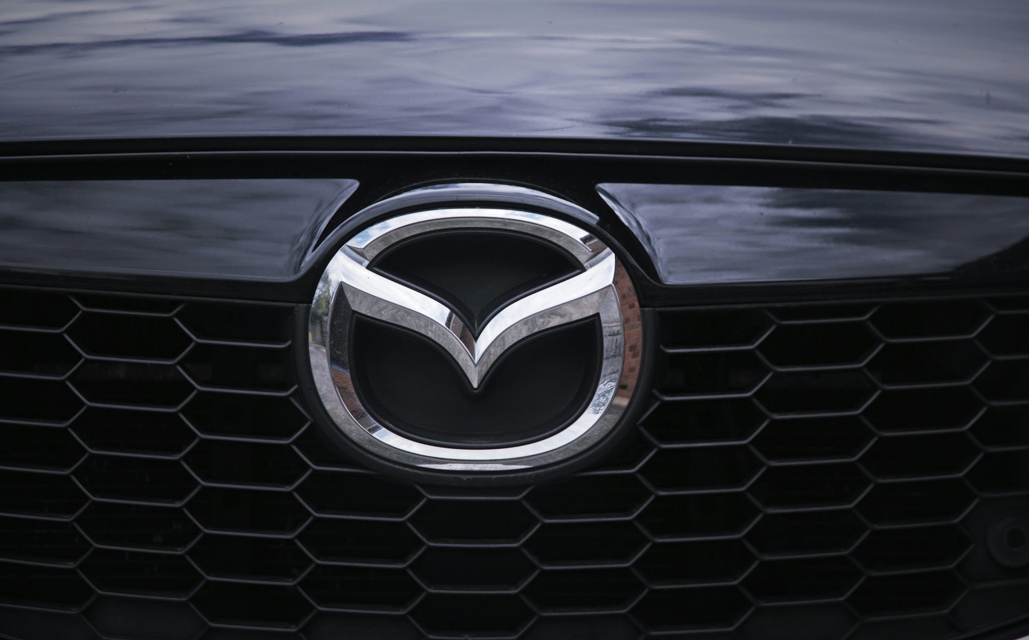 a close up of the Mazda logo on front grill
