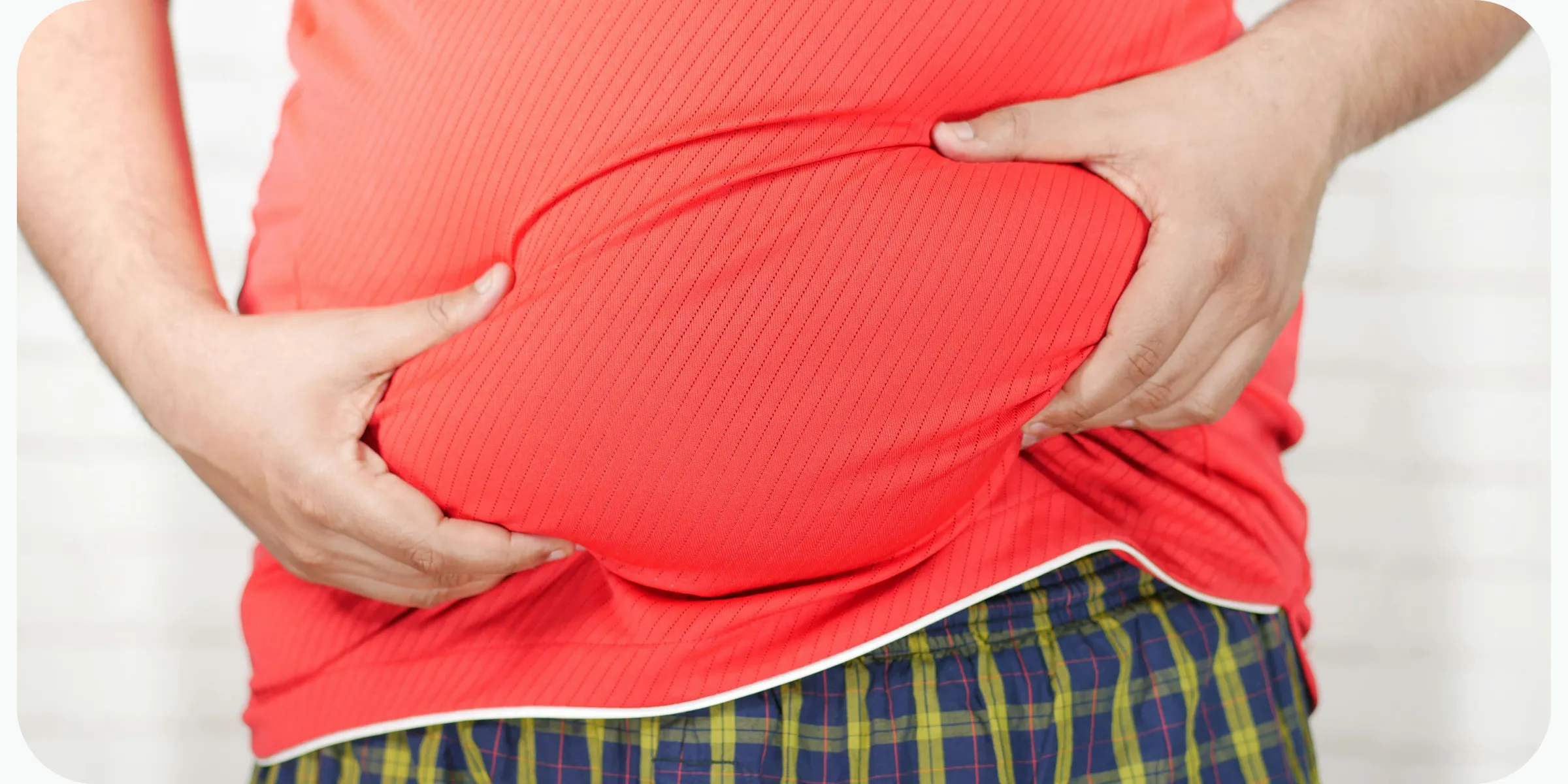 Man holding his abdomen, illustrating excess weight and obesity