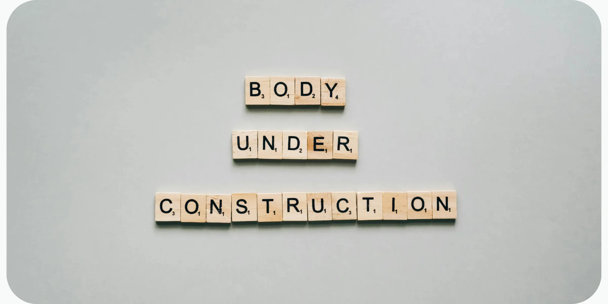 Scrabble tiles spelling 'Body Under Construction', a weight loss journey concept