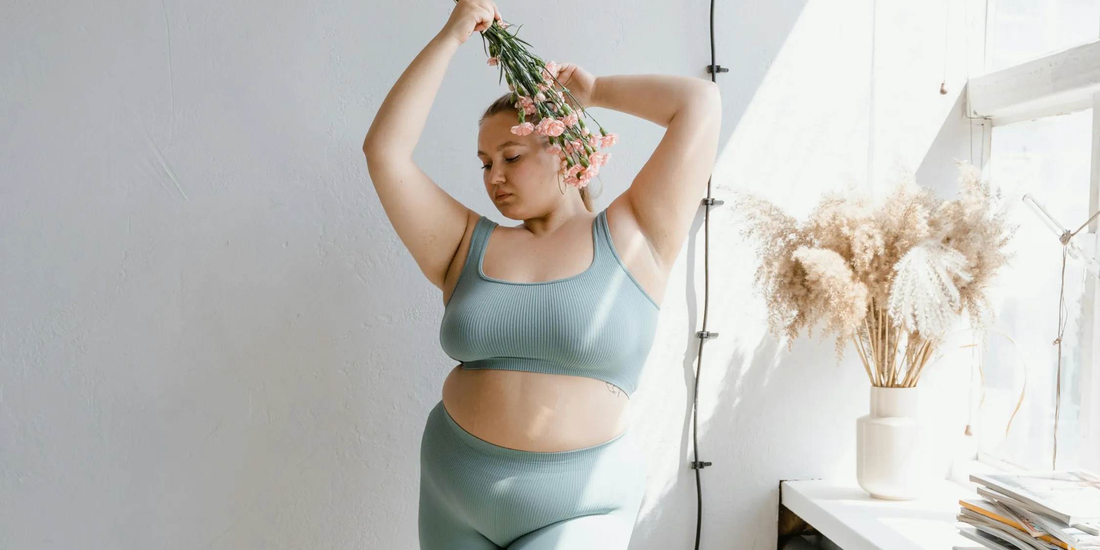 Woman in activewear holding flowers, a healthy lifestyle and weight loss concept