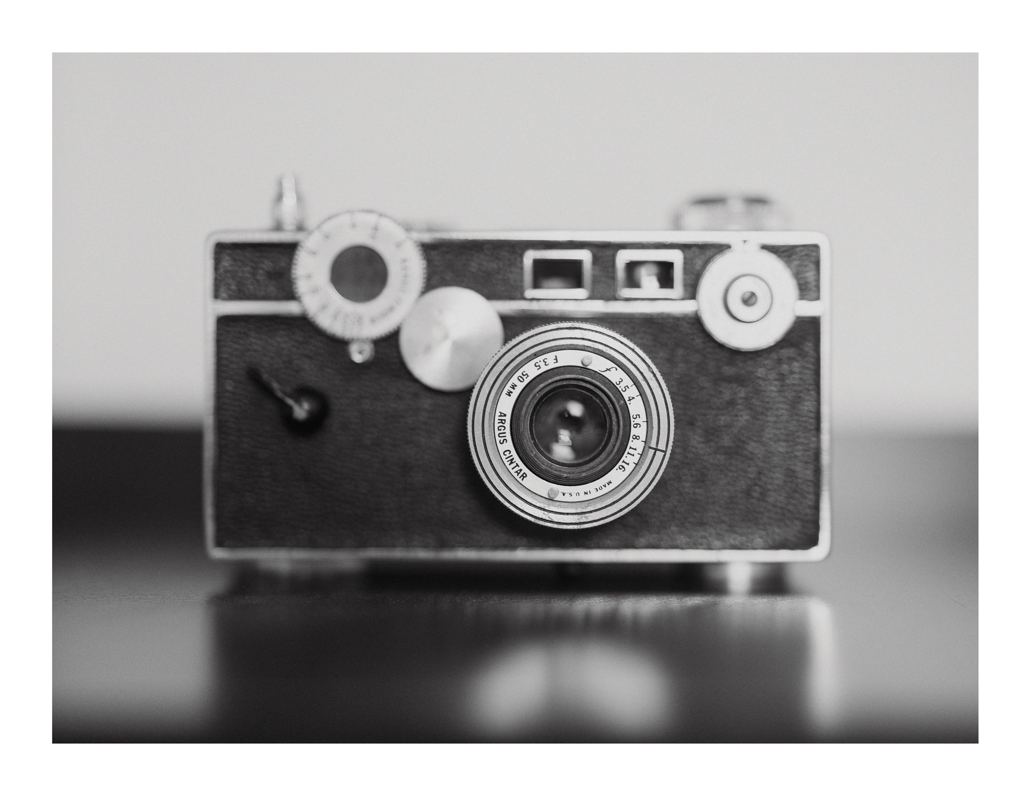 Black and white photo of a vintage Argus camera centered in soft focus
