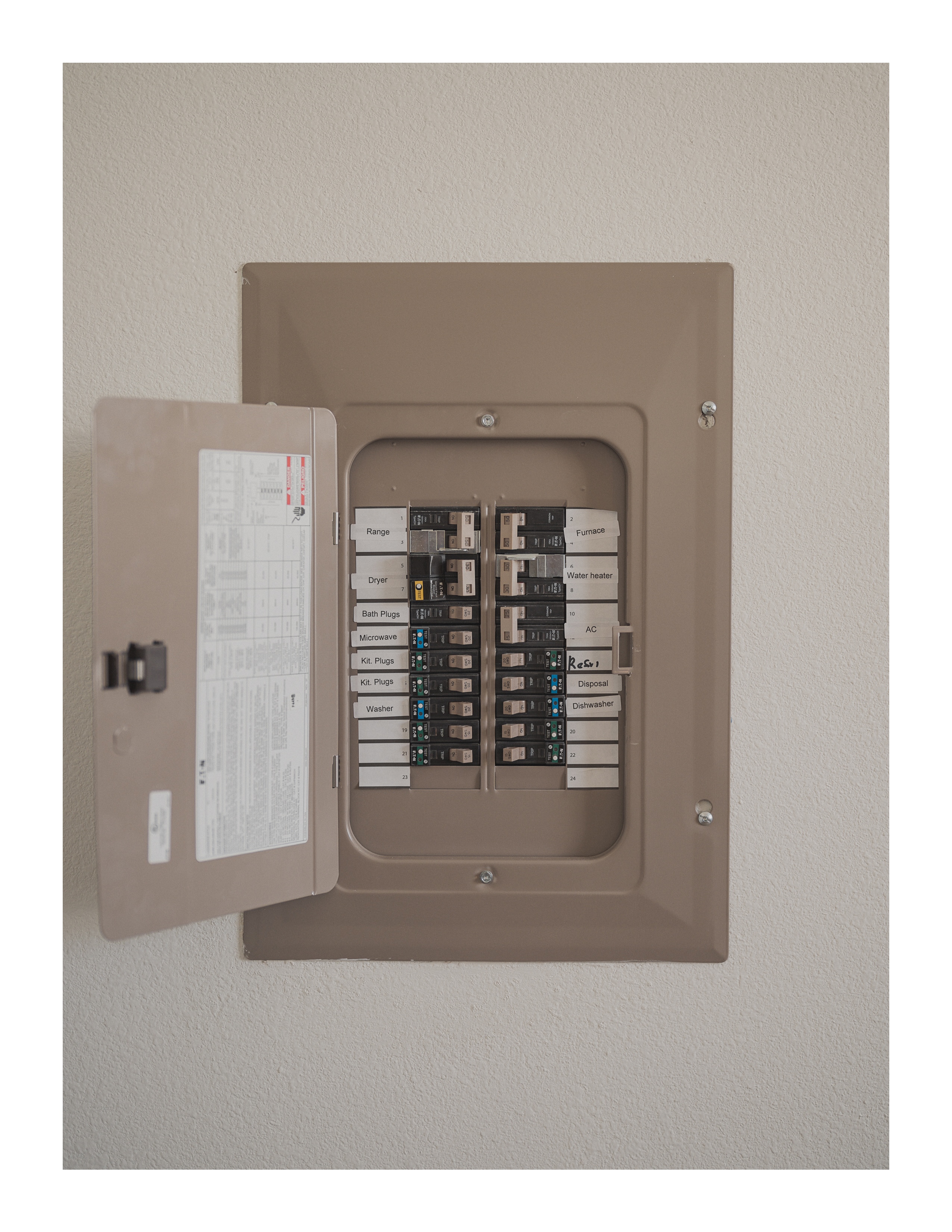 Labeled residential breaker box with open panel in soft natural light