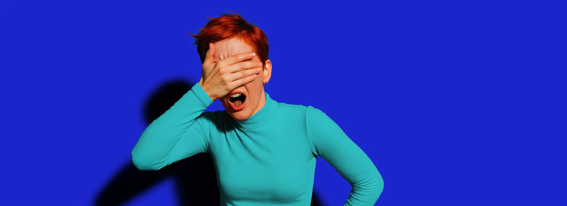 Jonge vrouw met hand voor haar gezicht