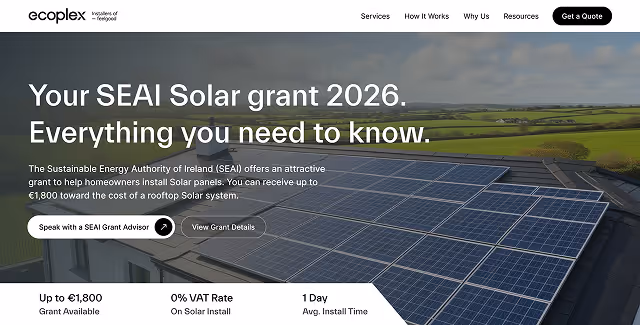 Rooftop solar panels installed on a house with green fields in the background under a cloudy sky.