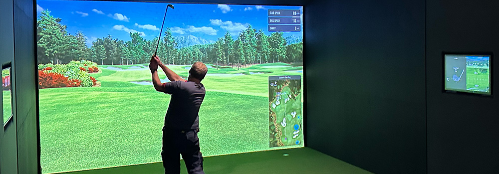 A golfer taking a swing in an indoor GolfSpace