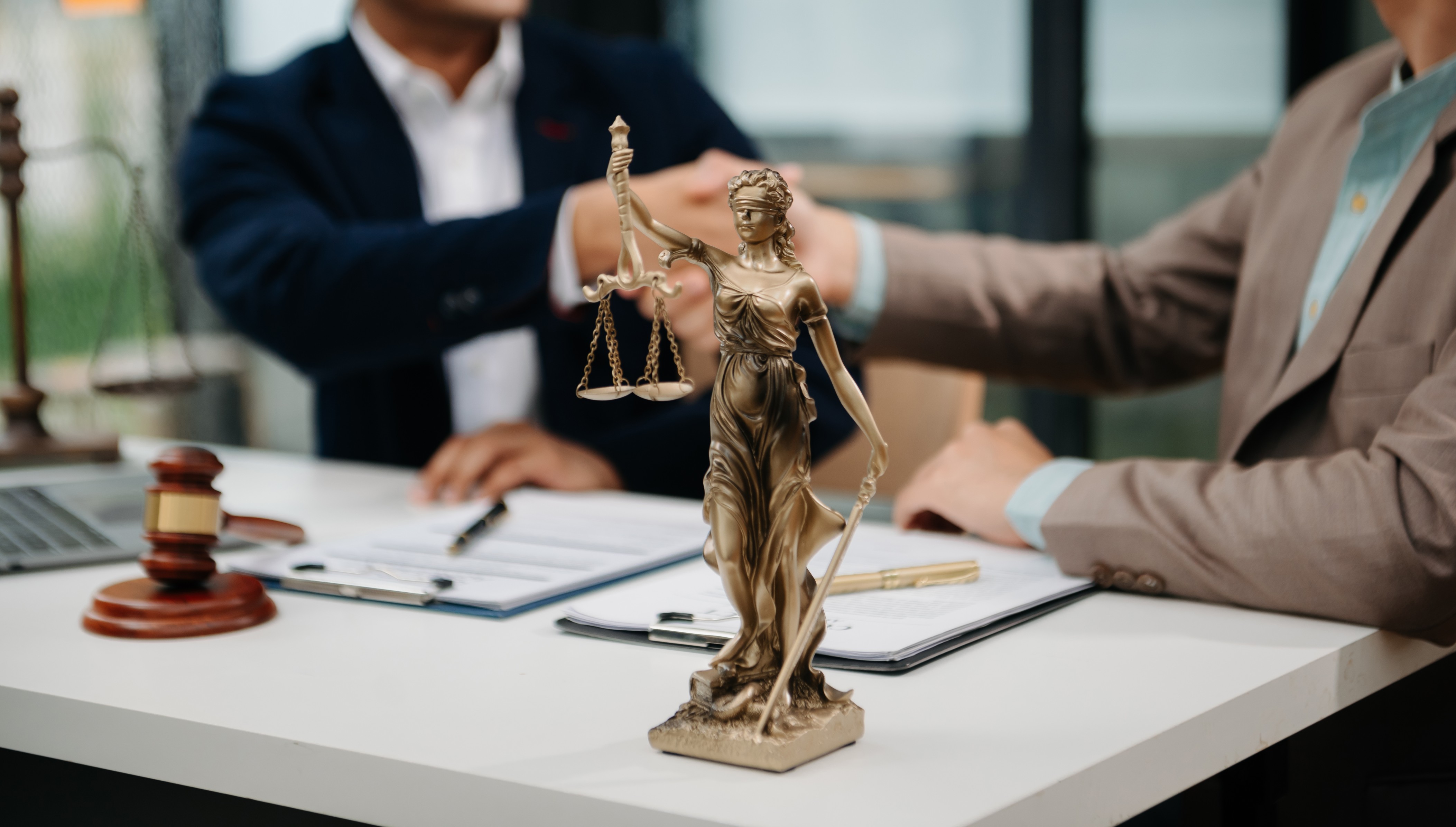 Attorney working at a desk with a brass scale of justice