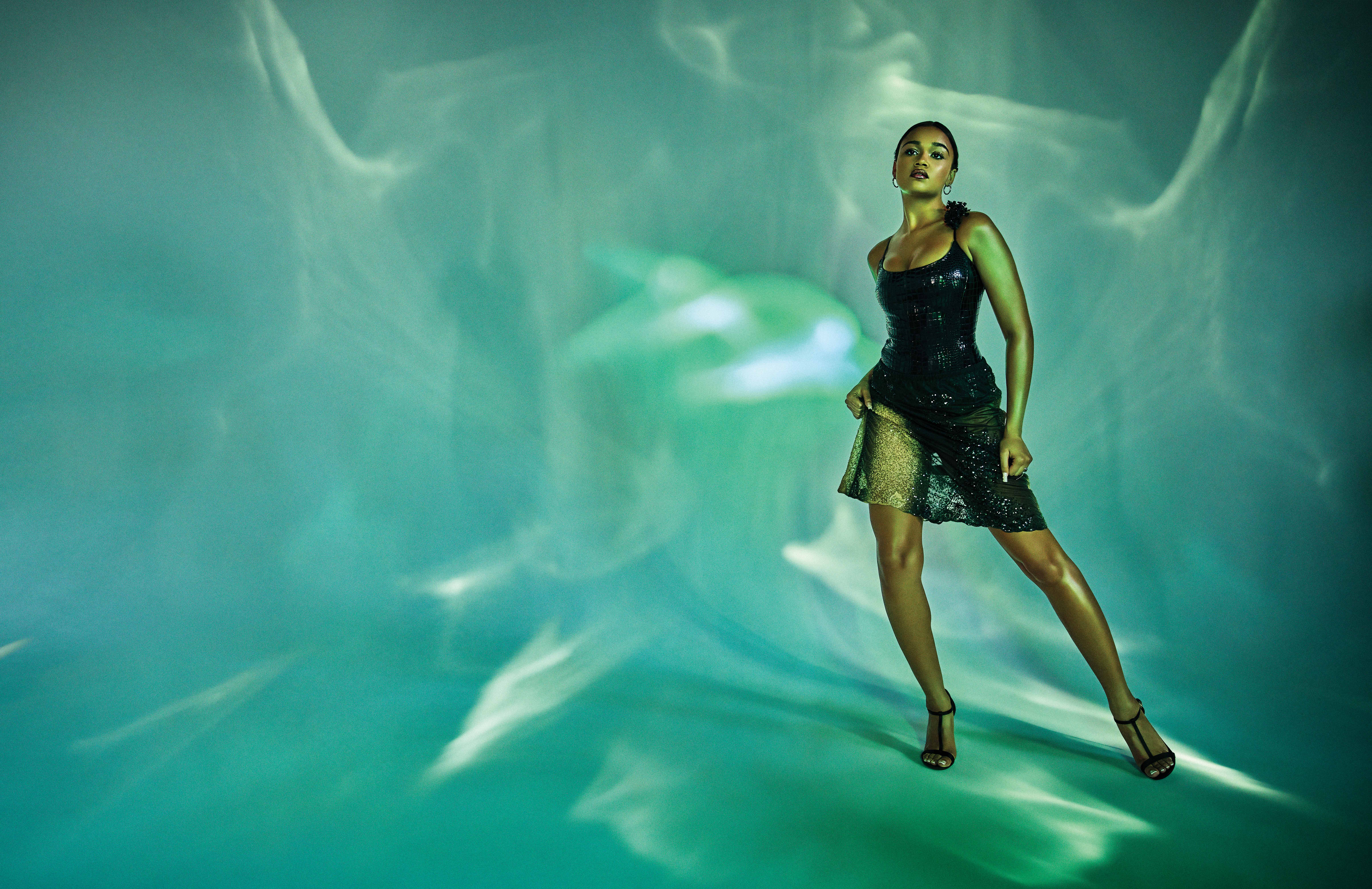 Woman with heals standing up on a neon-colored ground and background