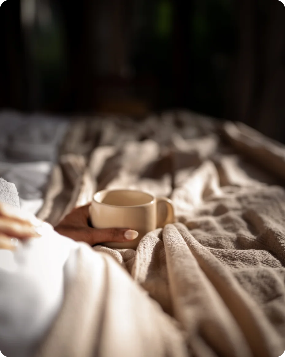 woman's-hand-enjoying-cup-of-coffee-in-bed