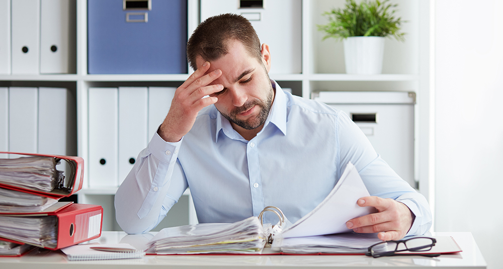 Pensive businessman calculates taxes