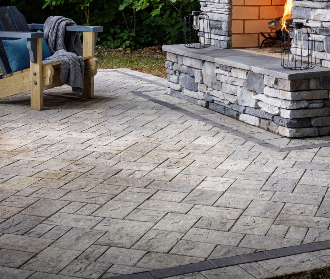 A patio of Belgrade Origins pavers emulates the look of natural stone as they surround an outdoor fireplace.