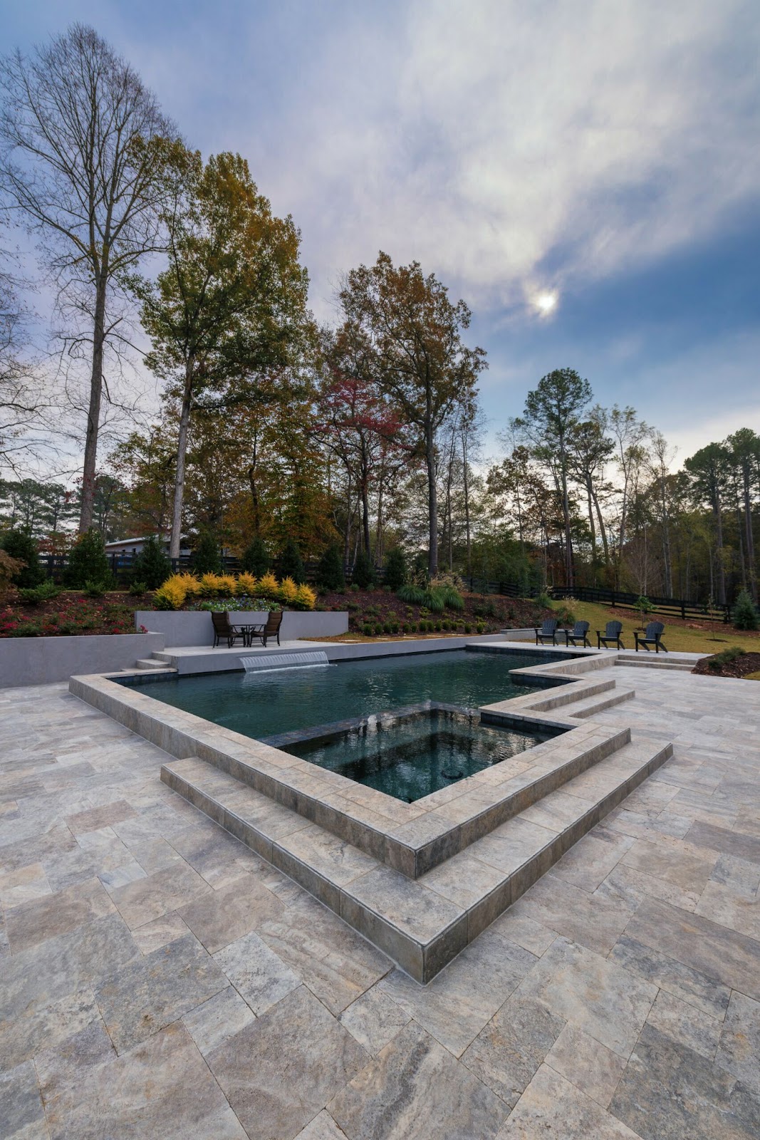 Travertine pavers create a beautiful patio surrounding a modern pool. 