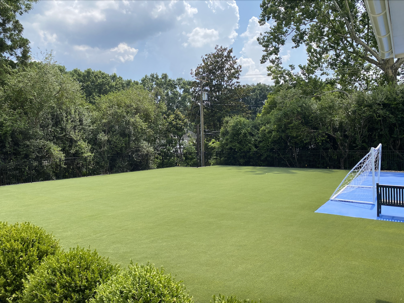 Artificial turf is utilized in a spacious backyard.