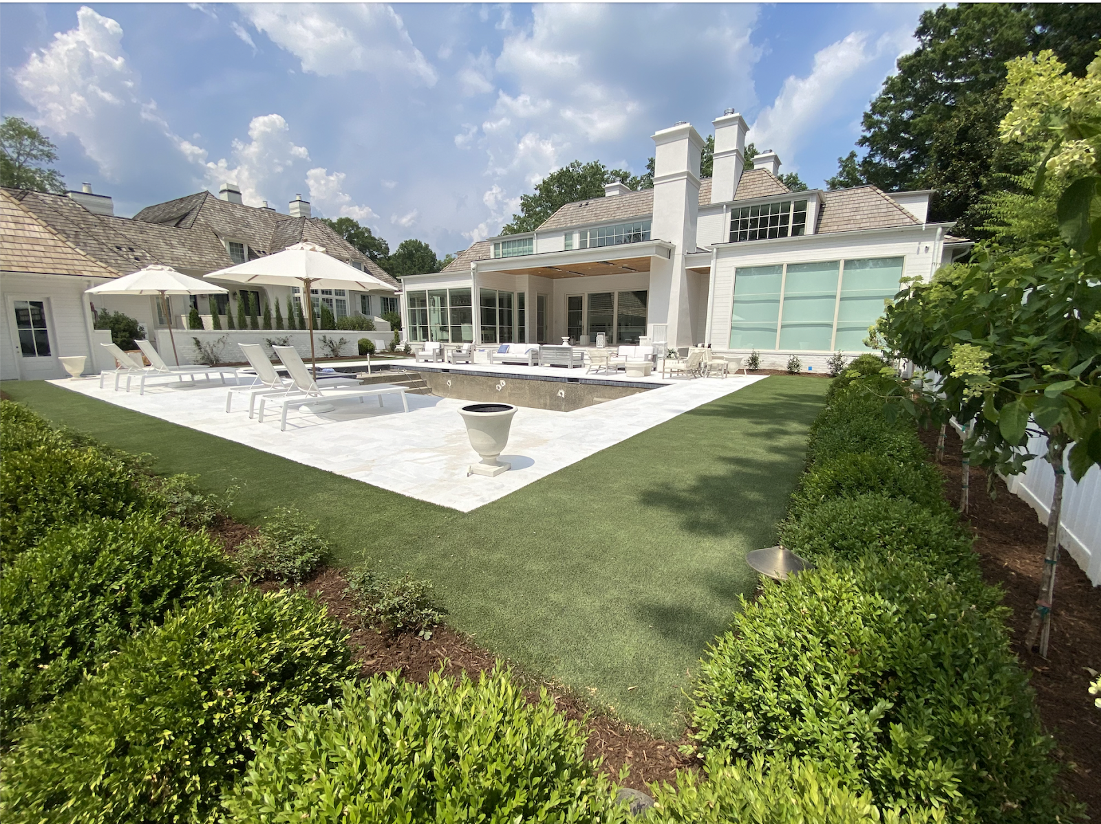 This image depicts an artificial lawn utilized in a backyard around a pool.