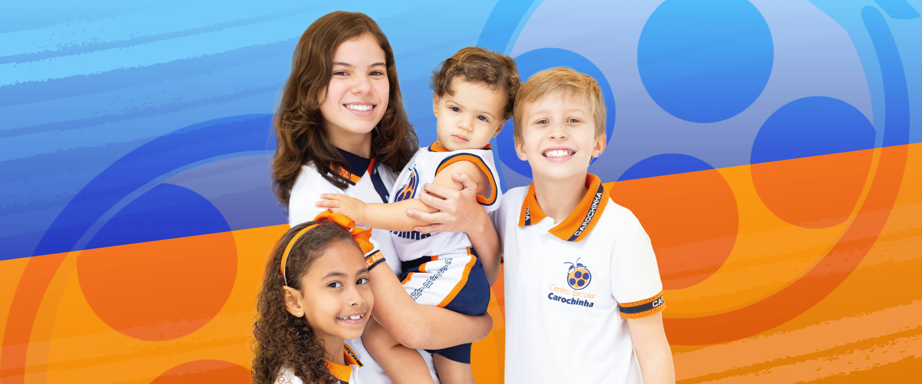 Crianças sorrindo com uniforme do Centro Escolar Carochinha, escola na Zona Norte de Recife com mais de 50 anos de tradição em educação infantil e novo berçário para bebês.