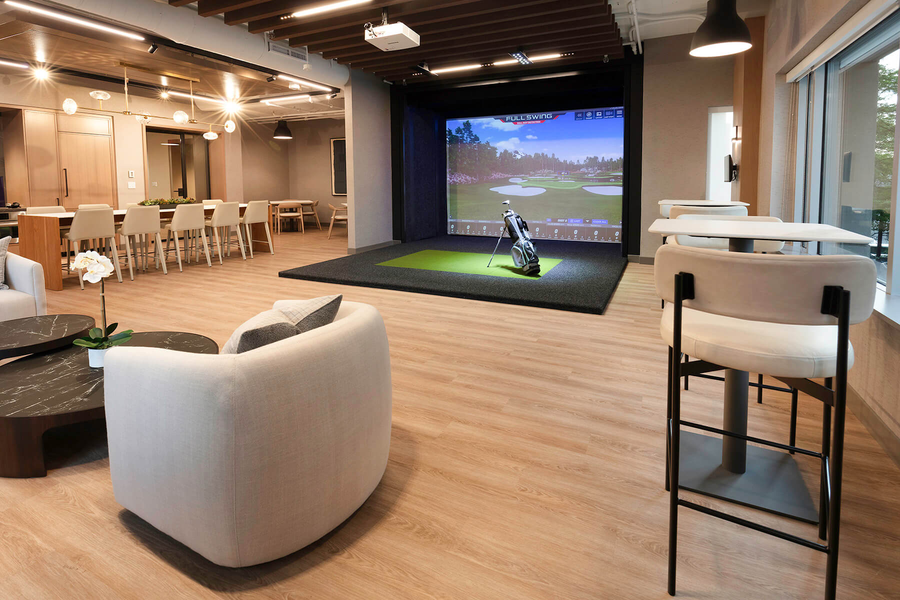Interior view of breakout seating and golf simulator.