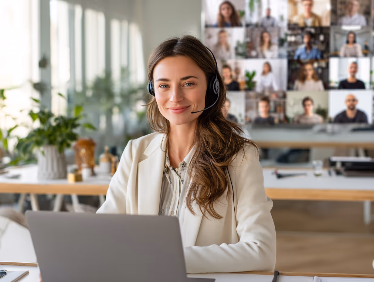 Smiling businesswoman on a video call with headset and laptop