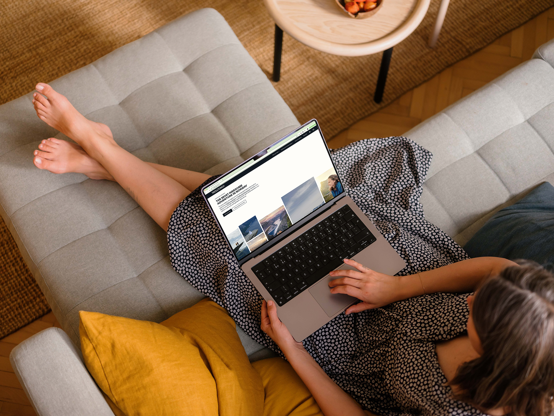 A person planning a hike on the Trolltunga website from the sofa
