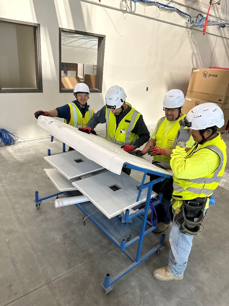 CleanSpace crew setting a wall panel in full PPE
