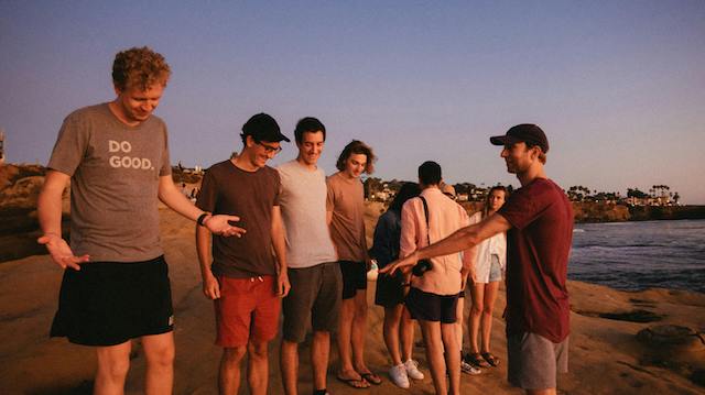 A group of men prepare to take a photo on the beach