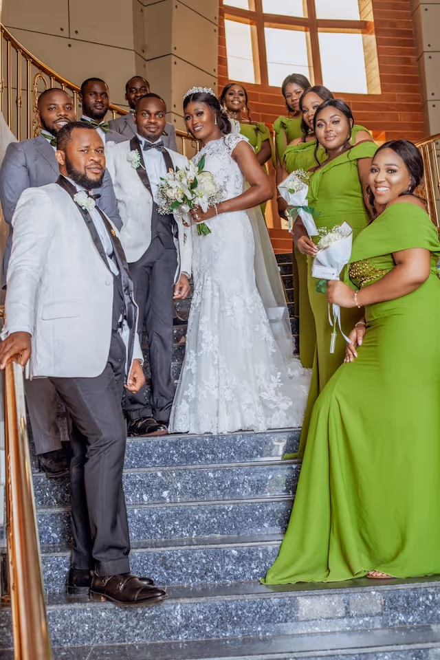 A wedding party poses on steps at a Pilot hotel.