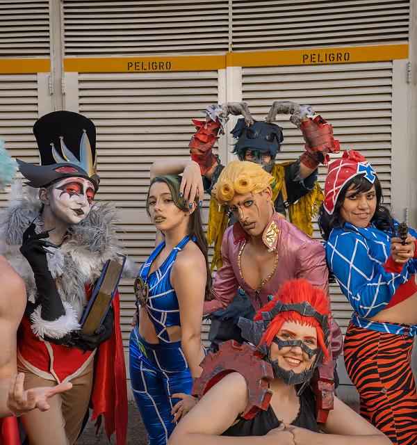 A group of six people wearing costumes for a convention