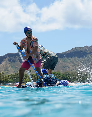 three men (two standing one laying) on paddle boards celebrating an outdoor bachelor party on Pilot
