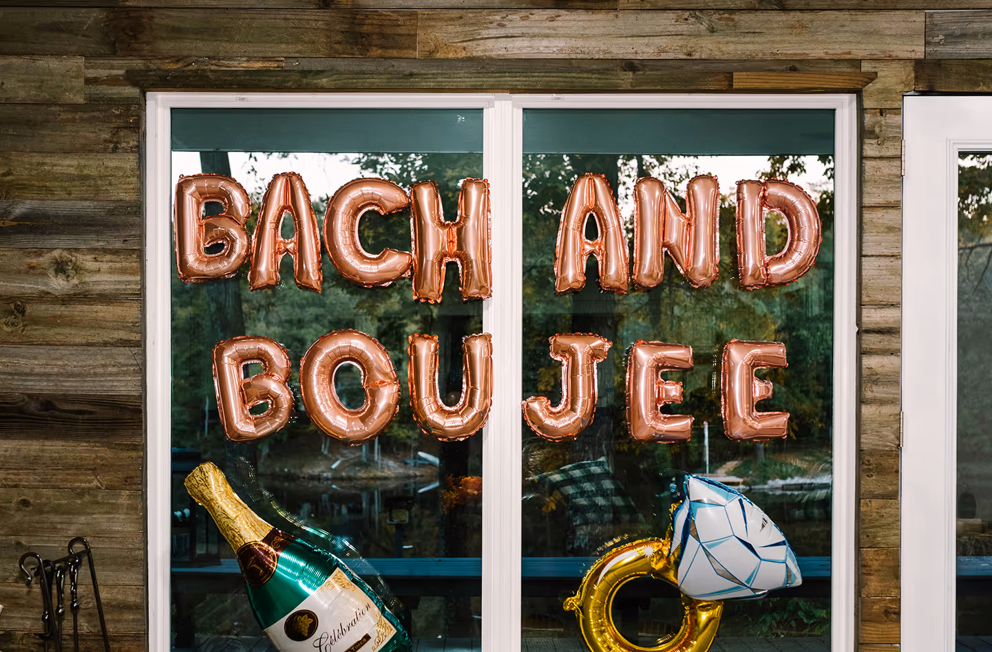 Bachelorette party decorations that include balloons that spell Bach and Boujee and a champagne bottle and diamond ring. 