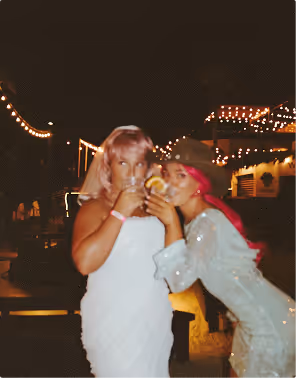 Two women in white sparkly dressed celebrate a Vegas Bachelorette planned on Pilot. 