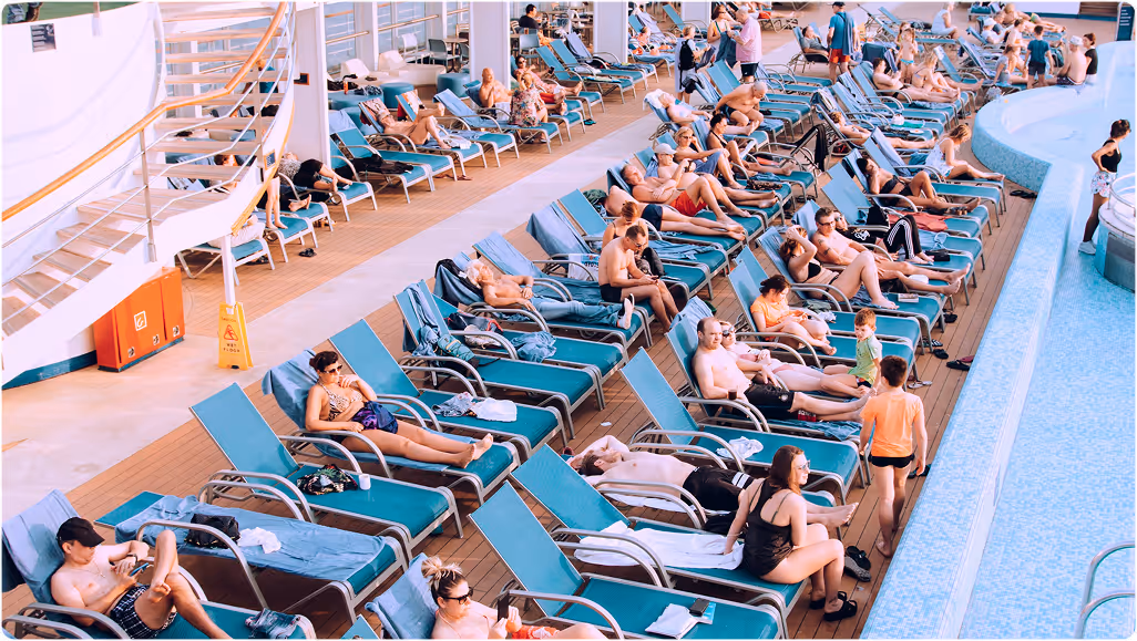 People relaxing on lounge chairs while on a trip planned on Pilot beside a pool on a ship's deck.