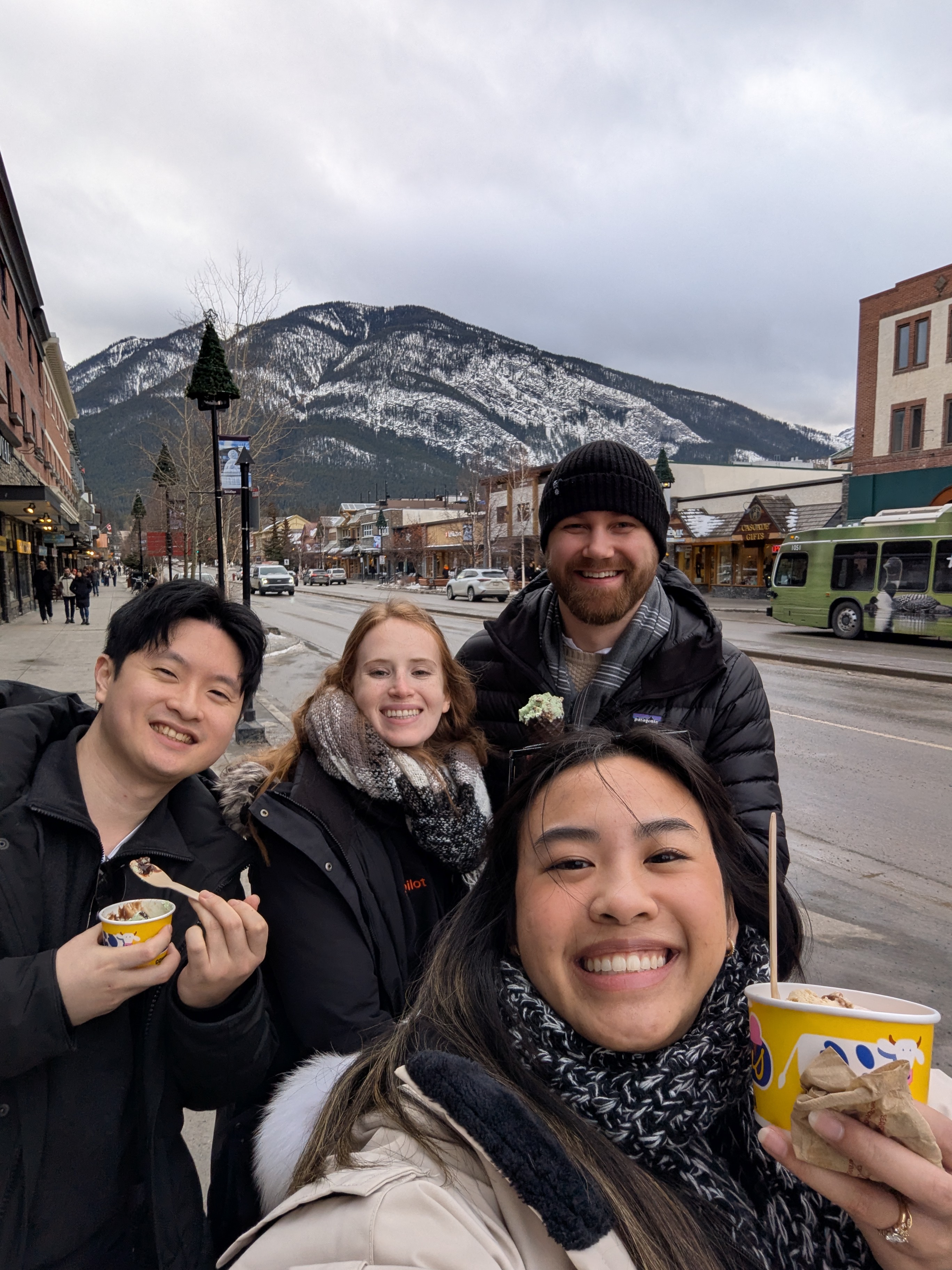 Three teammates taking a selfie on a snowy mountain-town street