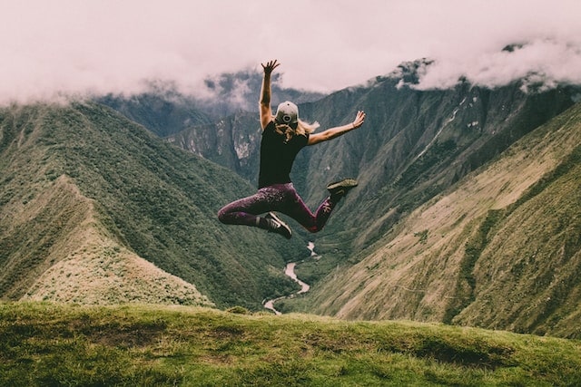Woman jumping in the air on a mountain top