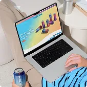 Person browsing the Magic Dose website on a laptop with a can beside them