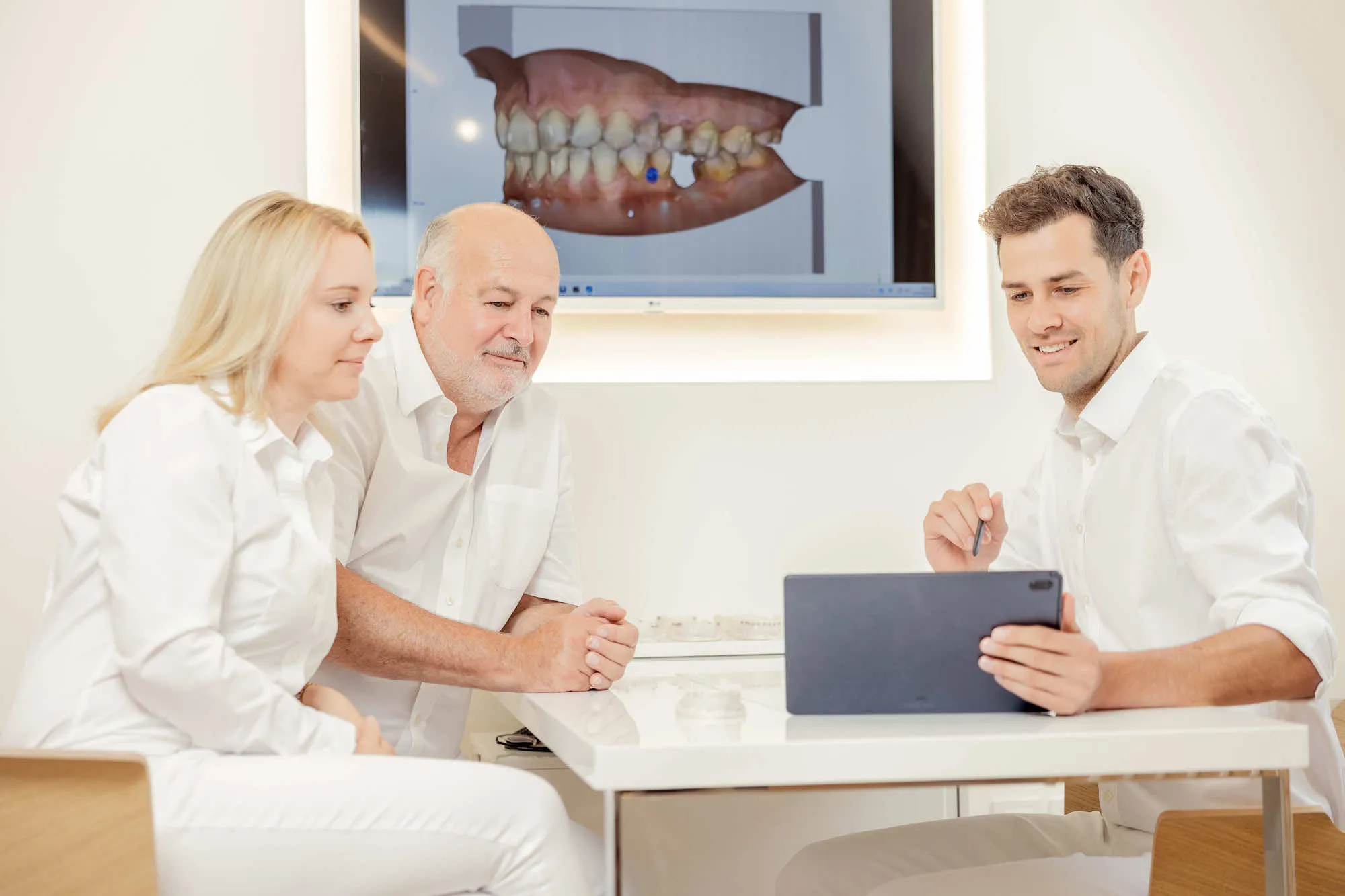 a couple of people sitting at a table with a laptop