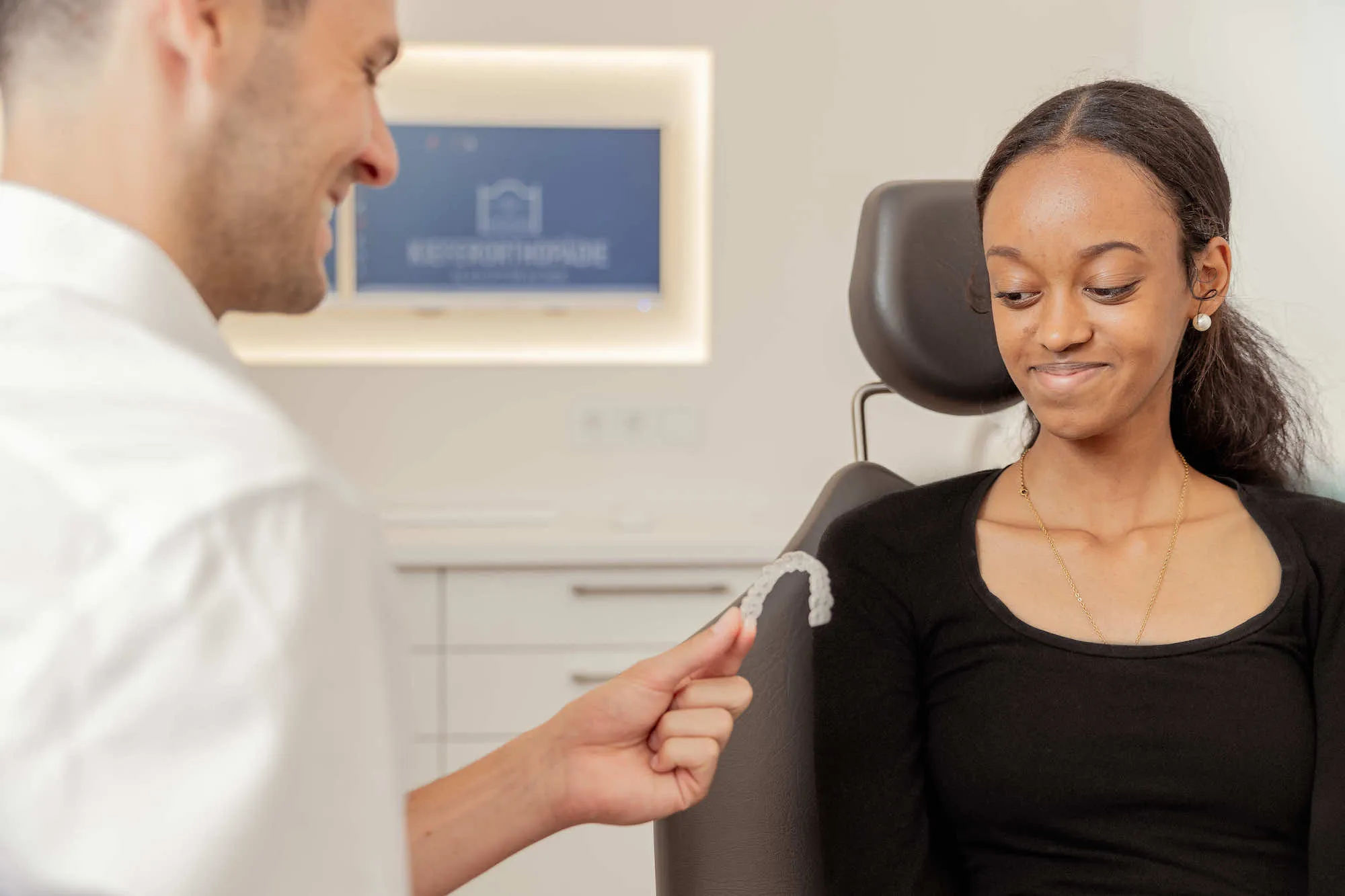 a woman sitting in a chair with a man in the background