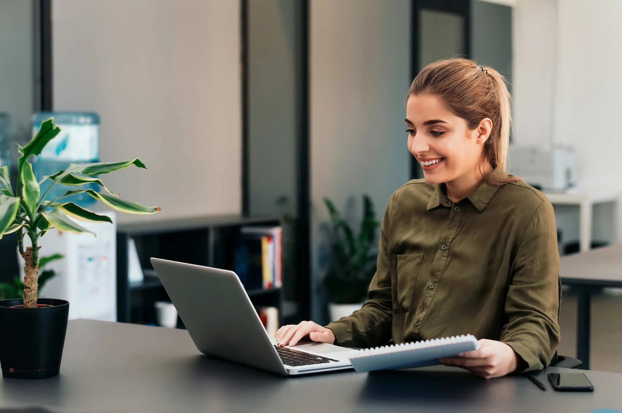 a woman sitting at a desk using a laptop computer