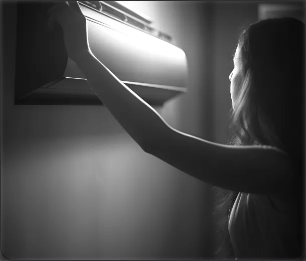 A person reaching to adjust an AC.







