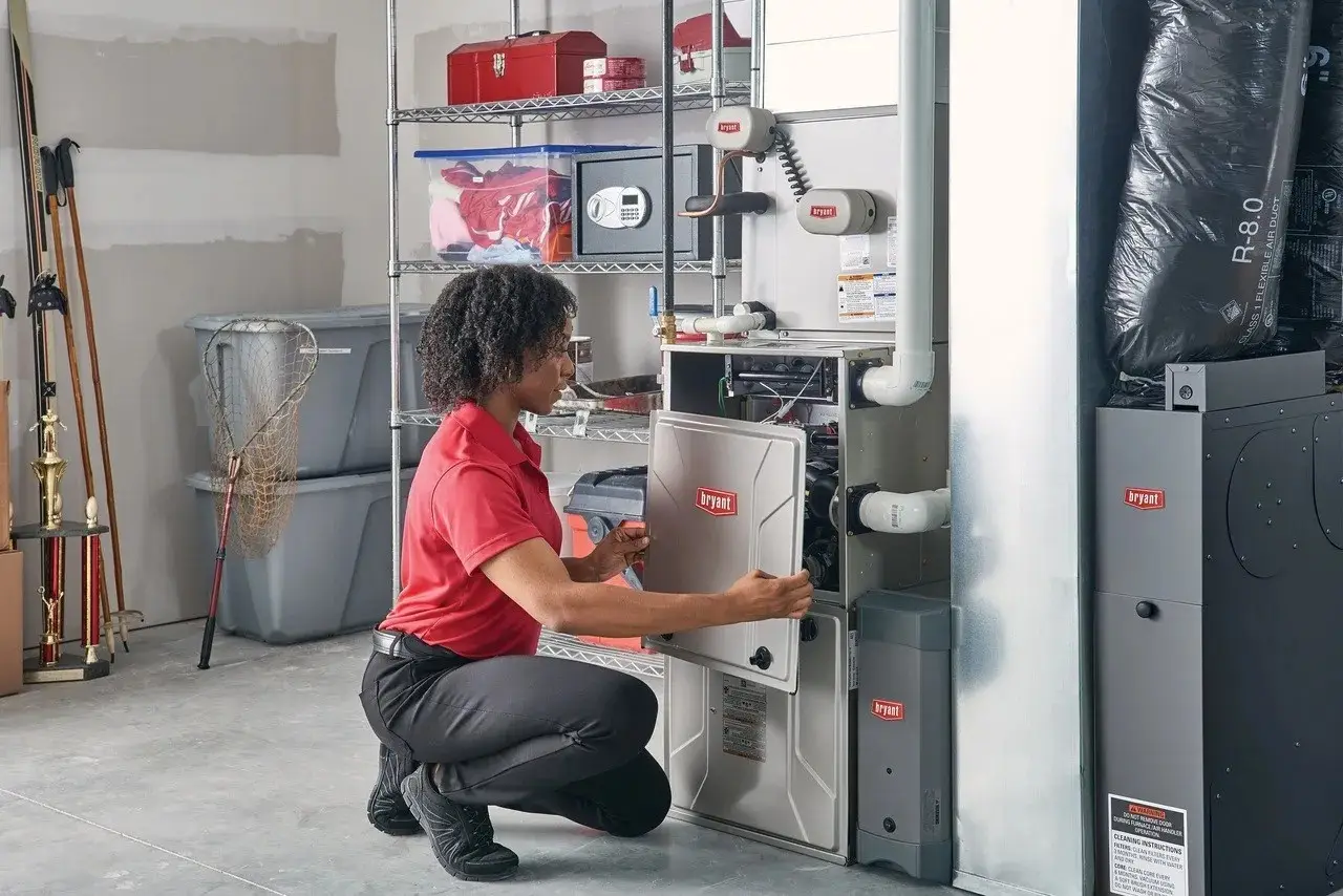 A women installing a Bryant indoor furnace system inside a basement area